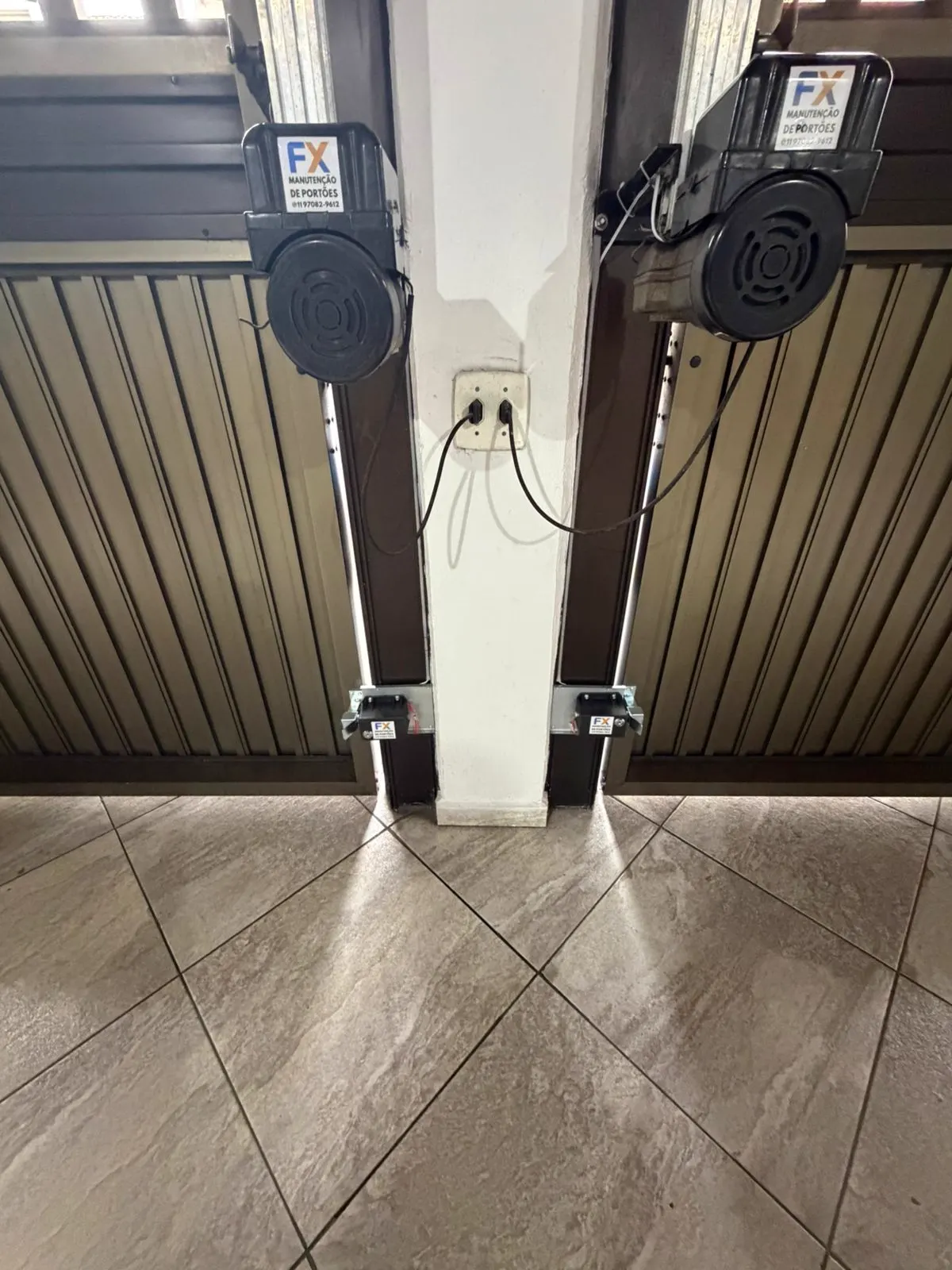 Portão pivotante duplo com motores automatizados em entrada residencial