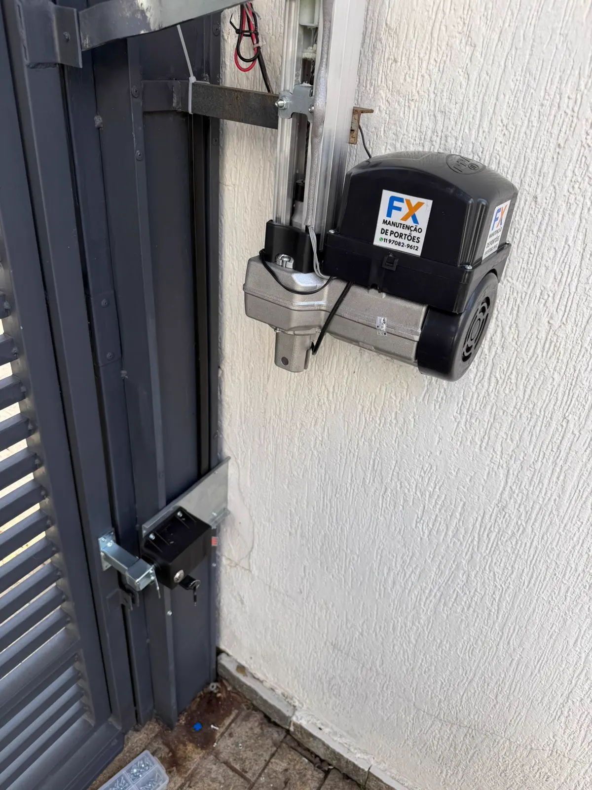Motor com braço articulado instalado em portão pivotante de garagem