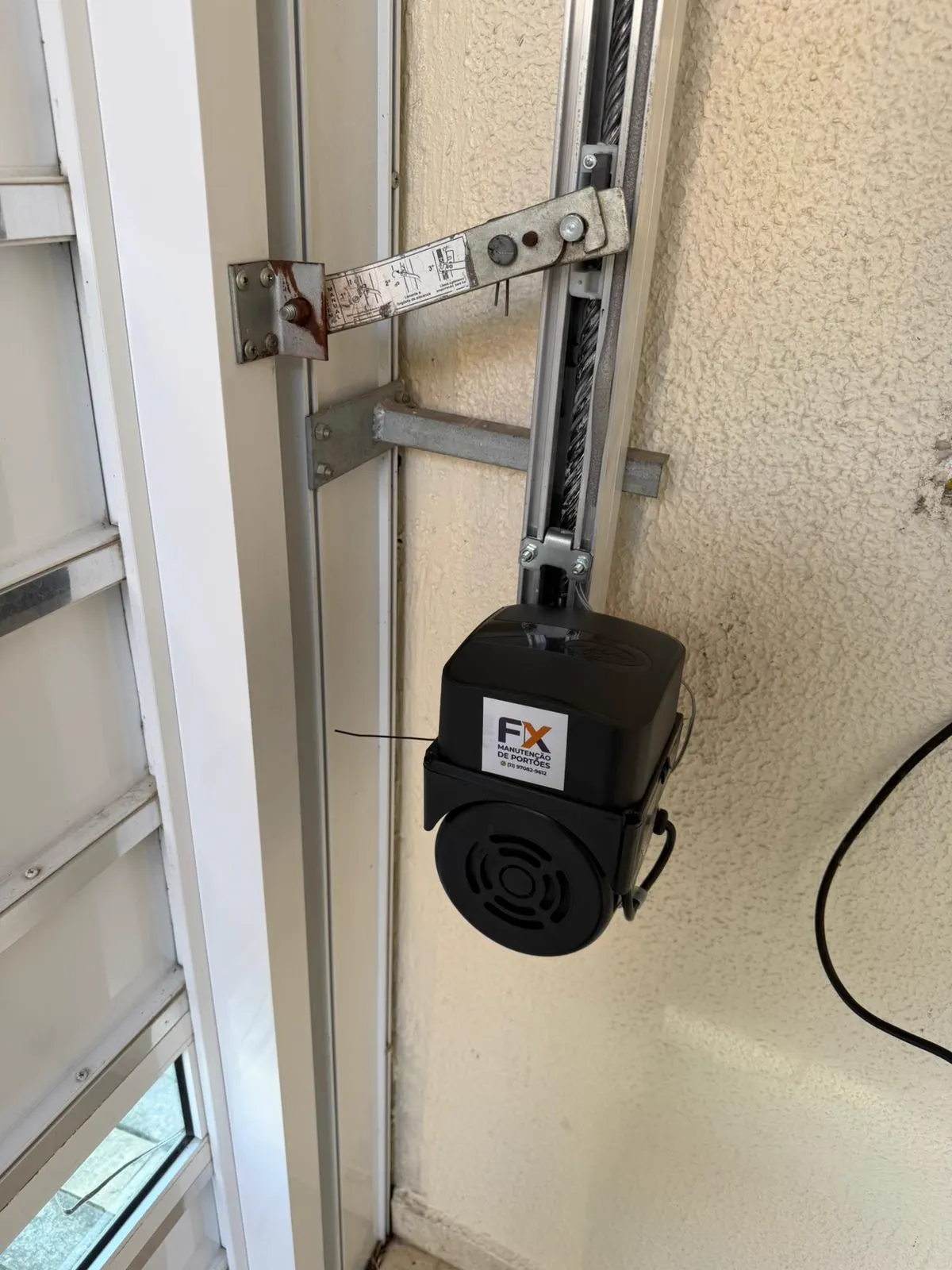 Motor instalado em portão basculante de garagem residencial